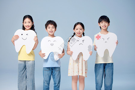 四个小朋友举着牙齿模型手举牌背景图片