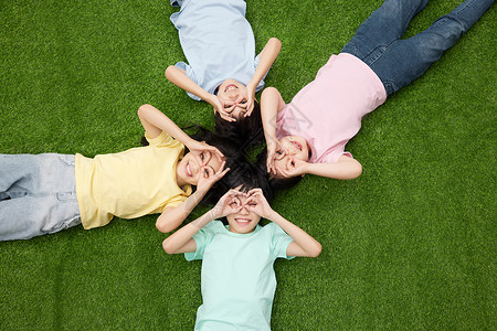 侧躺小女孩四个小朋友开心地躺在草地上背景