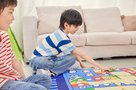 小男孩坐在客厅里玩飞行棋高清图片