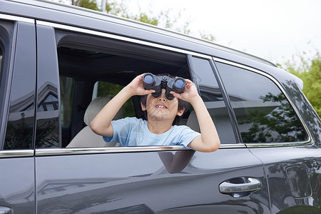 孩子在车里小男孩在车里看望远镜背景