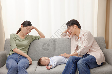 疲劳的年轻夫妻和睡觉的宝宝图片