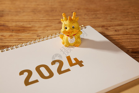 金色文字龙年新年2024金色日历和龙摆件背景
