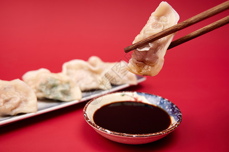 拿筷子夹饺子蘸醋背景图片