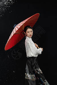 红扇子撑着红伞的古典马面裙女子背景