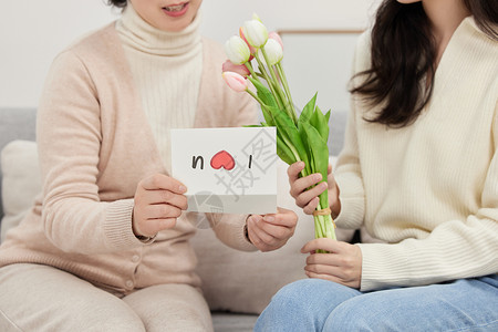 情感陪伴送卡片和鲜花给母亲局部特写背景