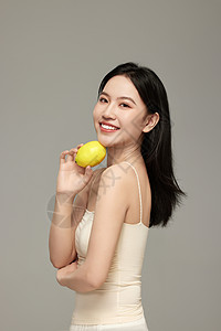 女人柠檬气质模特手上拿着新鲜柠檬摆拍背景