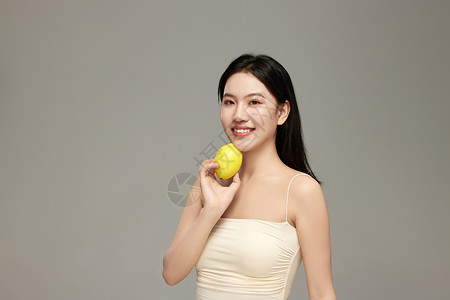 气质模特手上拿着新鲜柠檬摆拍背景