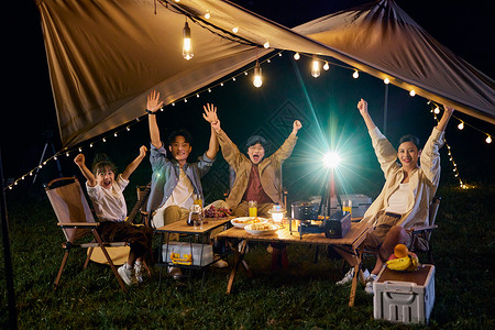 亲子拍照户外露营一家人举起手来快乐的拍照背景