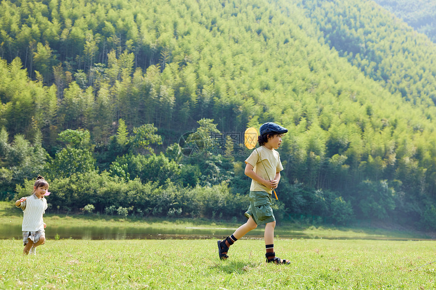 户外露营两个孩子在玩草坪上奔跑图片
