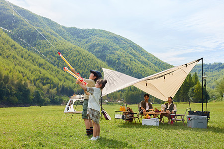  在公园玩户外露营两个孩子在玩泡泡机背景