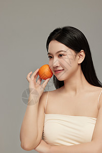 与橙子互动摆拍的专业模特形象背景图片