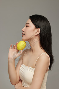 下巴放置柠檬拍照的专业模特形象高清图片