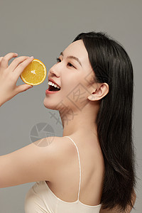 女性水果手里拿着橙子片的侧颜模特照背景