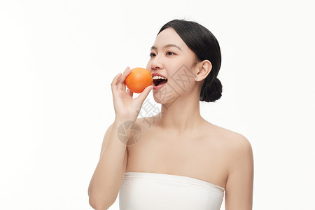 张开嘴巴摆拍吃水果的模特形象背景图片