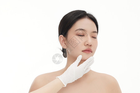手托下巴正在思考的医生图片整形医生正在用手确认女人下巴的状态背景