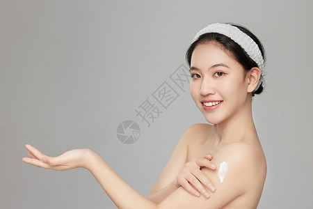 身体乳主图微笑展示手臂上身体乳的年轻女孩背景