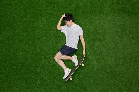 滑板青年创意俯拍拿着滑板耍帅的青年背景