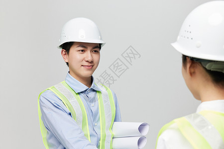 尖角帽微笑握手的男工程师背景