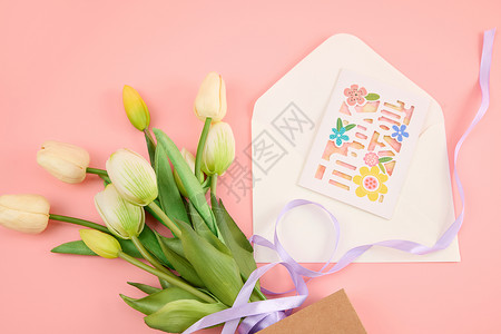 花多贴纸粉色桌面上一束白色郁金香和一个打开的信封背景