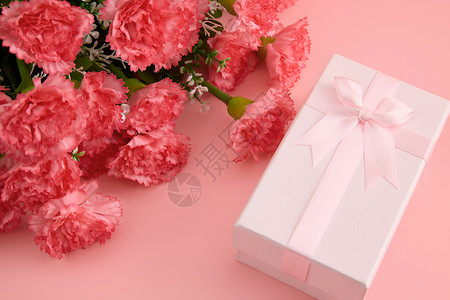 粉色波点蝴蝶结一大束娇艳欲滴的红色康乃馨和粉色蝴蝶结礼物盒背景