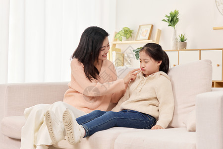 教导训话年轻妈妈正在逗弄生气的女儿背景