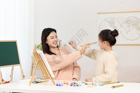 画笔画画儿童拿着水彩颜料嬉笑玩耍的母女俩背景
