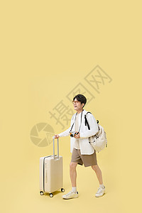 行走照片素材背着书包推着行李箱旅游的年轻大学生背景