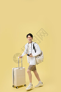 背着书包推着行李箱旅游的年轻大学生背景图片