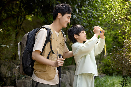 旅游的男人小男孩用相机拍山景背景