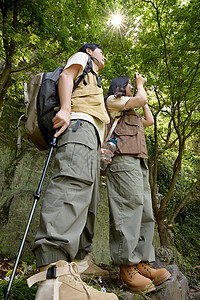 年轻人旅行一对情侣拿着相机在拍山上景色背景