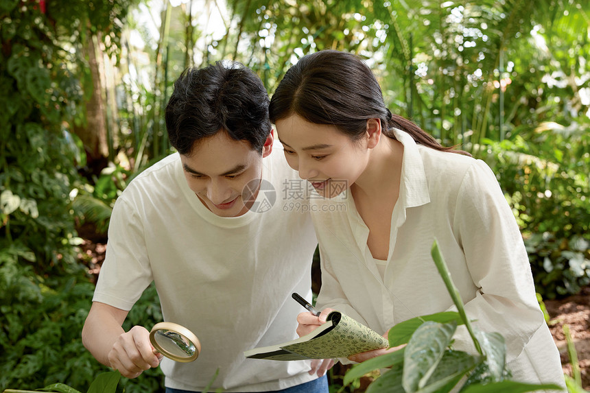 植物园里拿着放大镜和笔记本的专业人员图片