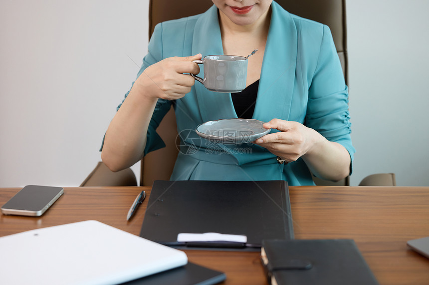 女白领在办公室喝咖啡特写图片