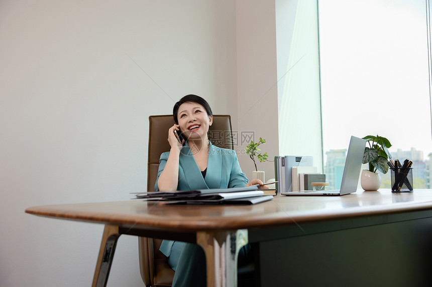 女白领坐在办公室里打电话图片