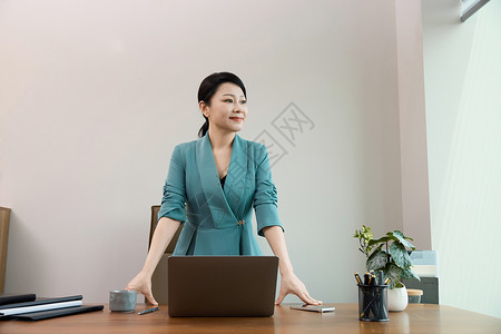在电脑前办公女白领在办公室站在电脑前背景