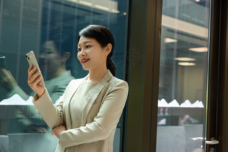 女商人工作女白领在办公大楼走廊拿着手机背景