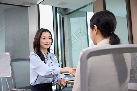 领导女商人女职员与女领导在办公室握手背景