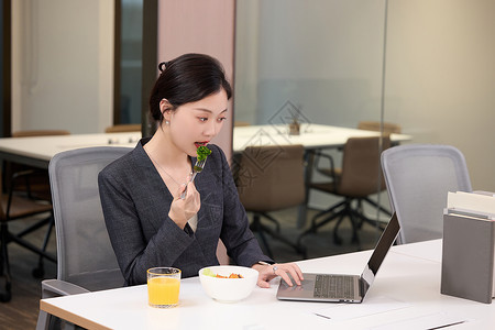 轻食优惠券办公室里正在吃轻食的女职员背景