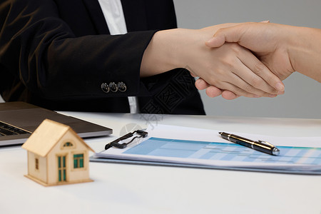 房屋资产房产销售与顾客握手特写背景