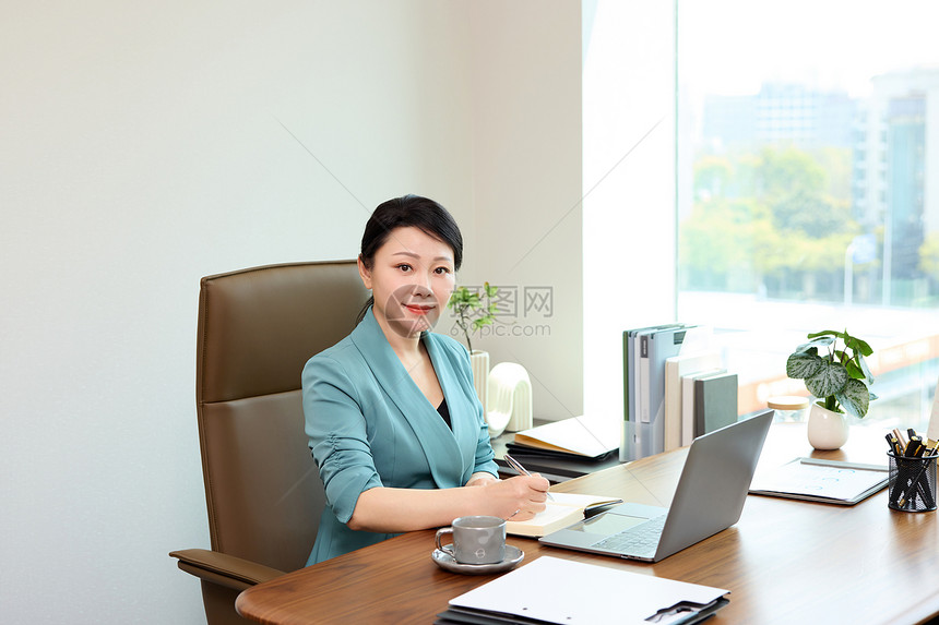 坐在办公室微笑的女老板形象图片