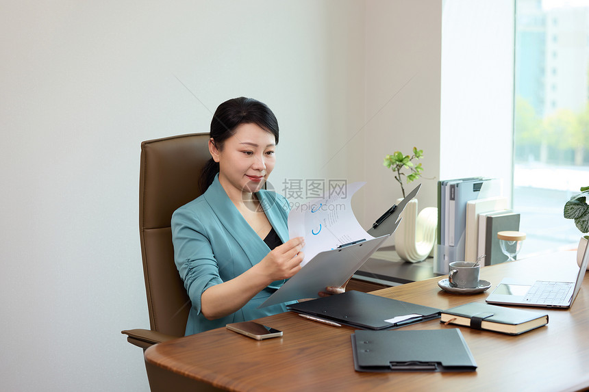 坐在办公室翻看文件的女老板图片