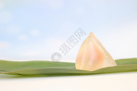 一片粽叶上的粉色冰皮水晶粽子高清图片