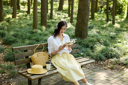 耳机女素材坐在长椅上戴着耳机听歌画画的女孩背景