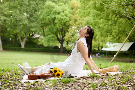 坐在野餐垫上休息的美女高清图片