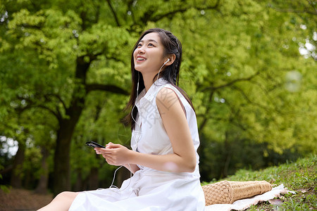 女孩坐蘑菇坐在野餐垫上休息的美女背景