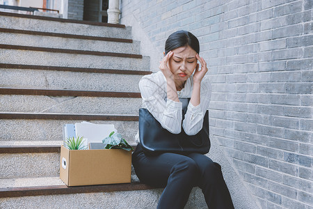 坐在楼梯上因失业而伤心的女职员高清图片