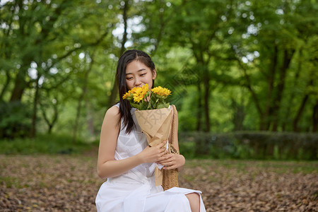 抱着花的女孩线稿户外抱着向日葵花束的美女背景