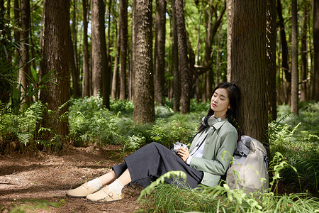 躺着乘凉的女孩美女坐在树下乘凉休息背景