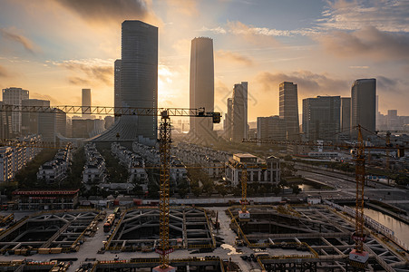 设备吊装航拍清晨城市建筑施工工地背景