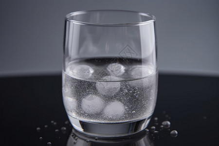 冰水杯在灰色背景上的一杯水中设计图片