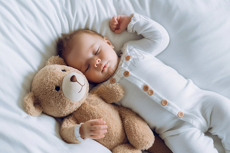 婴儿在床上抱着小熊睡觉高清图片